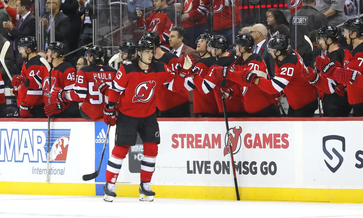 New Jersey Devils defenseman Ryan Graves (33) celebrates with teammates after scoring a goal against the Calgary Flames during the second period of an NHL hockey game, Tuesday, Nov. 8, 2022, in Newark, N.J. (AP Photo/Noah K. Murray)
