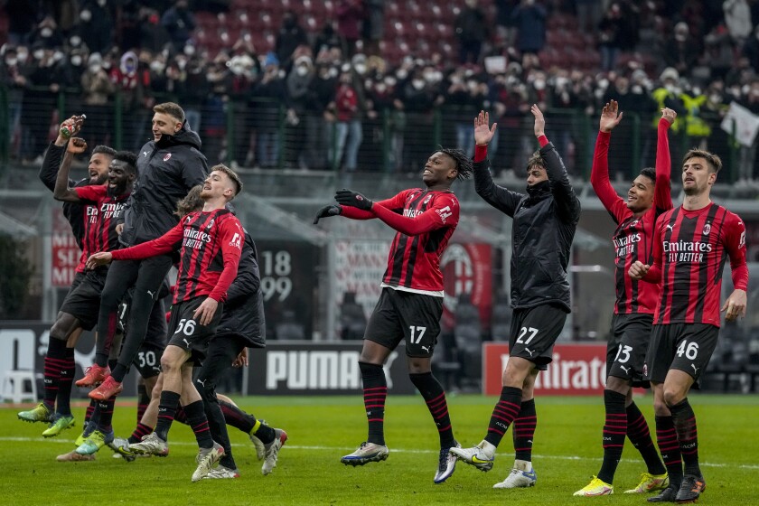 AC Milan's players celebrate their victory at the end of the Italian Cup soccer match between AC Milan and Genoa at the San Siro stadium in Milan, Italy, Thursday, Jan. 13, 2022. (AP Photo/Antonio Calanni)