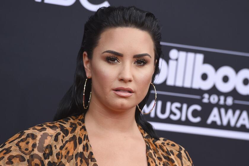 Demi Lovato posing in hoop earrings