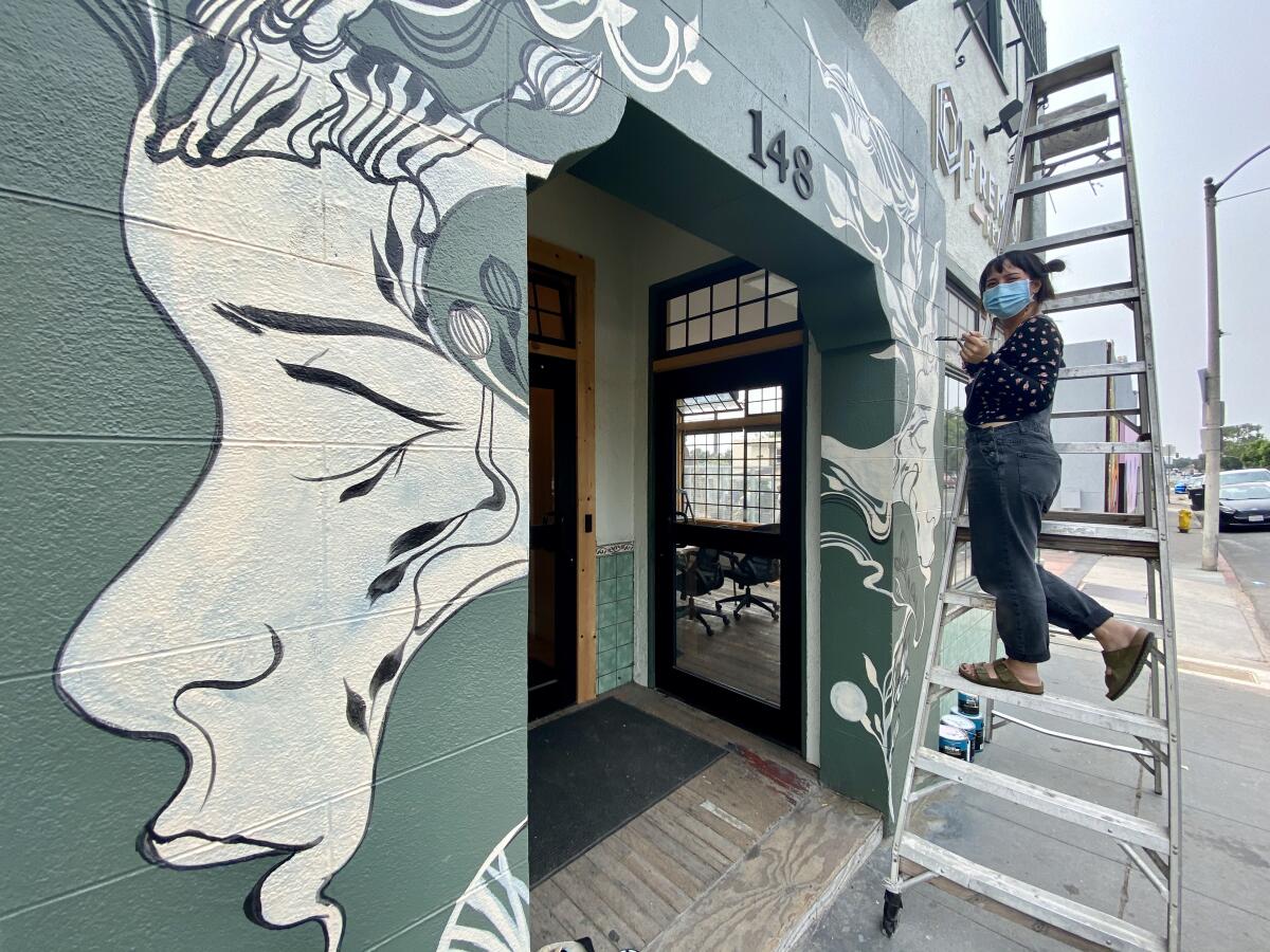 Mary Jhun, in front of her mural on the NOLA apartment building in San Ysidro.