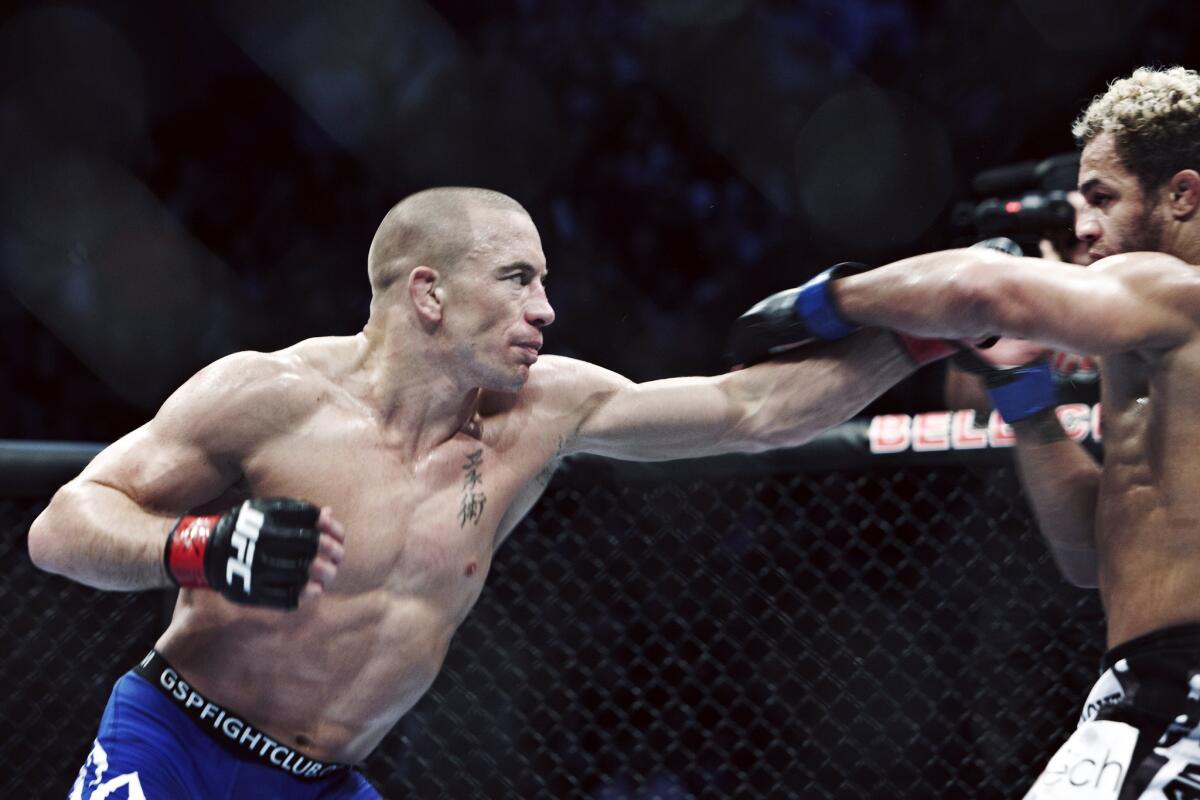 Georges St-Pierre, left, throws a punch in a fight against Josh Koscheck on Dec. 11, 2010.