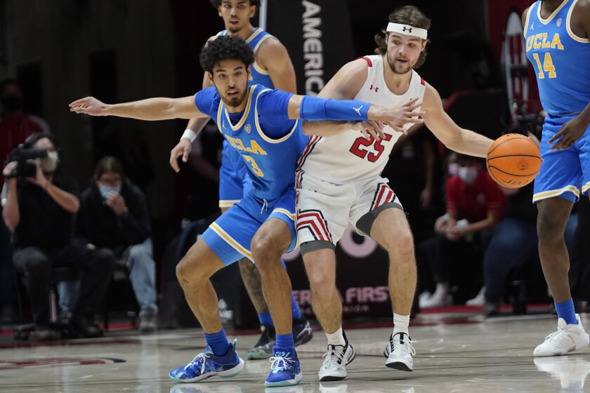 UCLA guard Johnny Juzang, left, defends against Utah guard Rollie Worster during the Bruins' win Thursday.