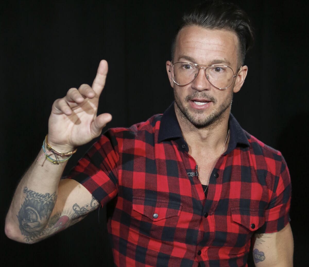 A man in glasses and a short sleeve red and black plaid shirt.