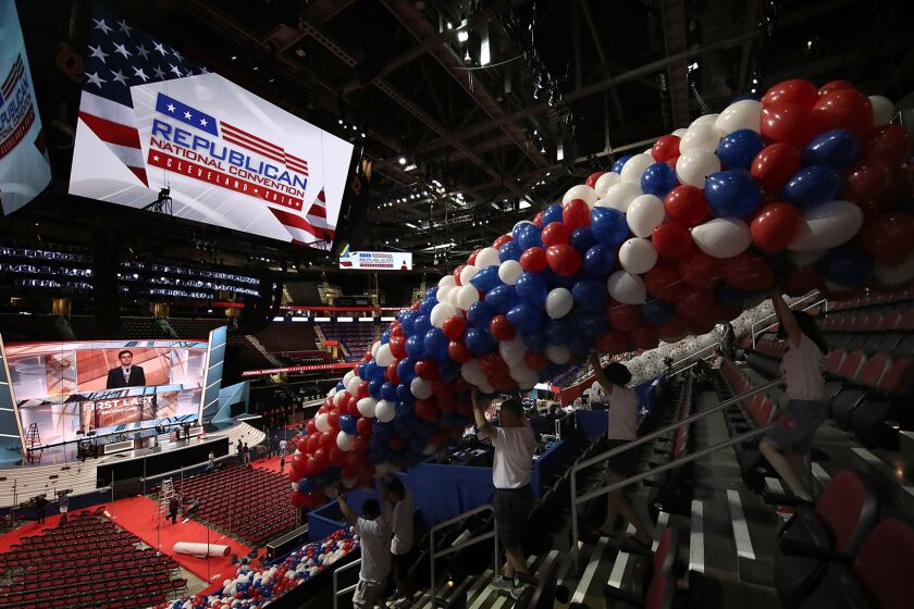 Volunteers position some of the more than 150,000 red, white and blue balloons to be dropped from the ceiling during the Republican National Convention in Cleveland.