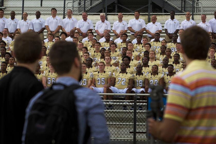 Members of the media look on as the UCF football team poses for their team photo on media day at the school on Friday, Augut 1, 2014. (Jacob Langston/Orlando Sentinel) ORG XMIT: ucf-football-0802