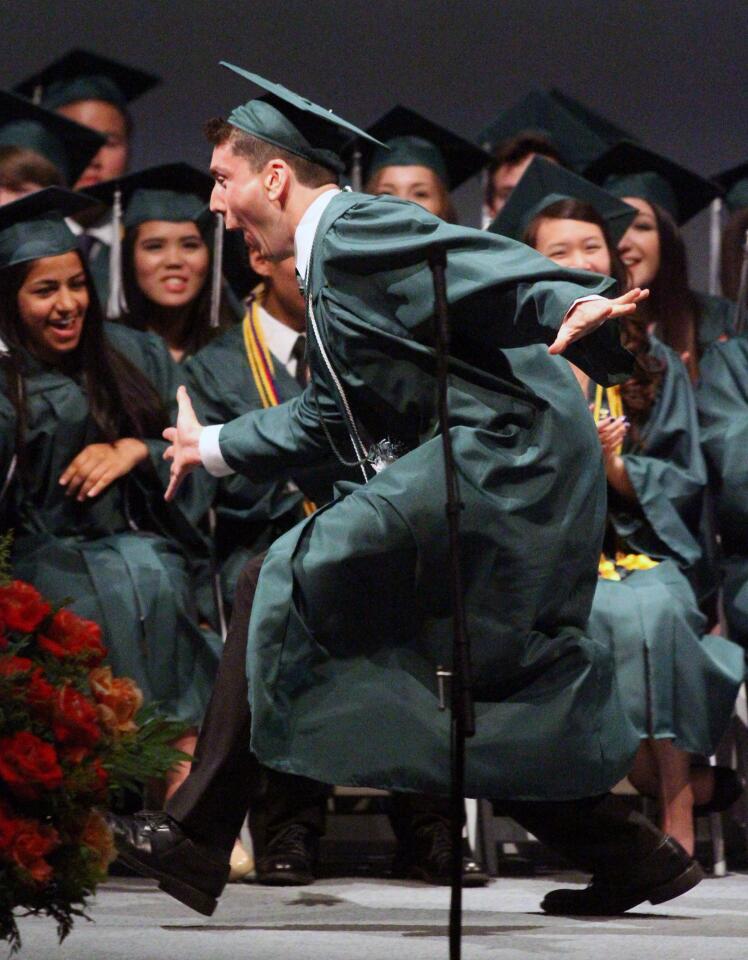 A student worthy of the Spirit Award Brandon Swofford runs and slaps the hands of fellow graduates in the front row as he runs to accept his award at the graduation of Providence High School on Saturday, June 7, 2014 at Forest Lawn in the Hall of Liberty in Los Angeles. (Tim Berger/Staff Photographer)