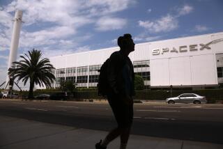 HAWTHORNE, CA - JULY 17, 2024 - A pedestrian walks past SpaceX in Hawthorne on July 17, 2024. Elon Musk said Tuesday on X that he is moving the headquarters of both SpaceX and the social media platform formerly known as Twitter to Texas - citing several criticisms he has of California. (Genaro Molina/Los Angeles Times)