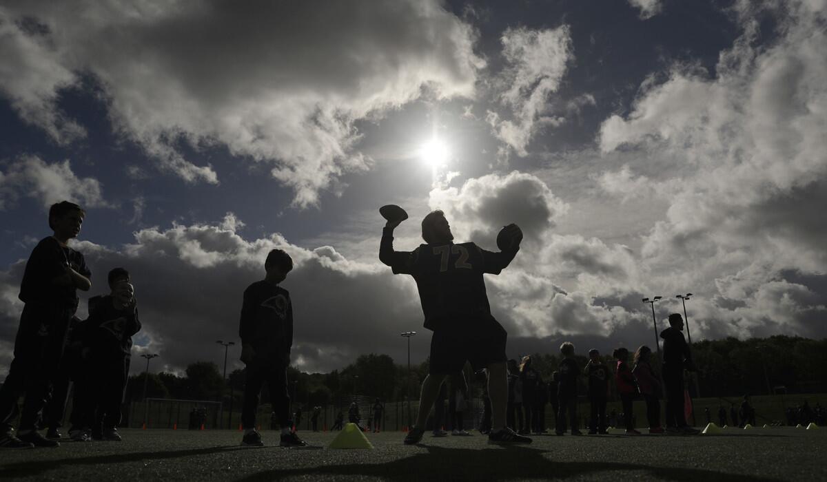 Rams offensive tackle Pace Murphy takes part in a drill with schoolchildren during an NFL community event at Surrey Sports Park in Guildford, England, on Tuesday.