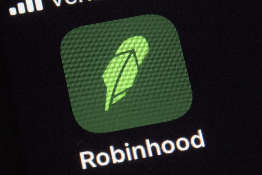 FILE - This Dec. 17, 2020 photo shows the logo for the Robinhood app on a smartphone in New York. Robinhood Financial will pay a $57 million fine and return another $12.6 million to thousands of its customers to settle accusations of a wide range of supervisory failures, such as hurting customers by giving them misleading information and improperly allowing some to make riskier trades. (AP Photo/Patrick Sison)