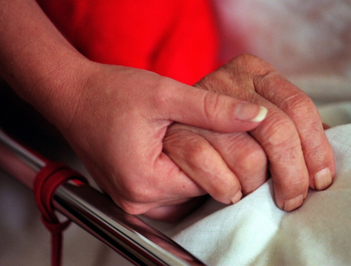 A hospice worker holds the hand of a patient with Alzheimer's disease. A new study shows a longevity gene may also give people higher cognitive abilities, suggesting a path toward bolstering the brain against diseases such as Alzheimer's.