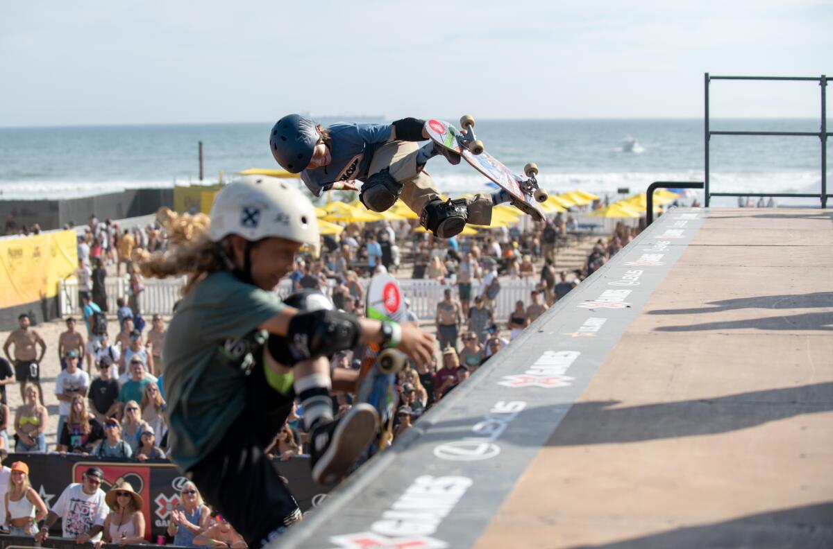 Banyan Meyer catches air as brother Valen Meyer exits a vert ramp built at Huntington Beach Pier on Sunday, Aug. 3.