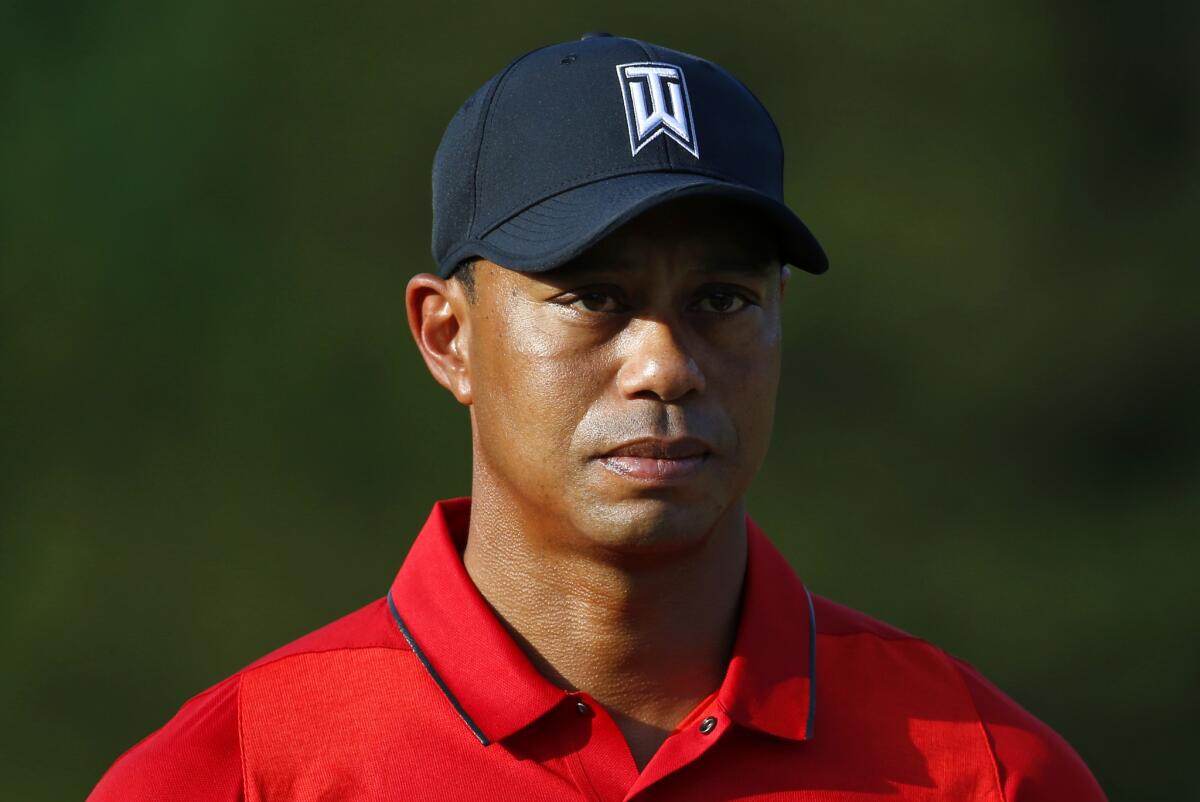 Tiger Woods takes part in a trophy ceremony for his Quicken Loans National on June 26.