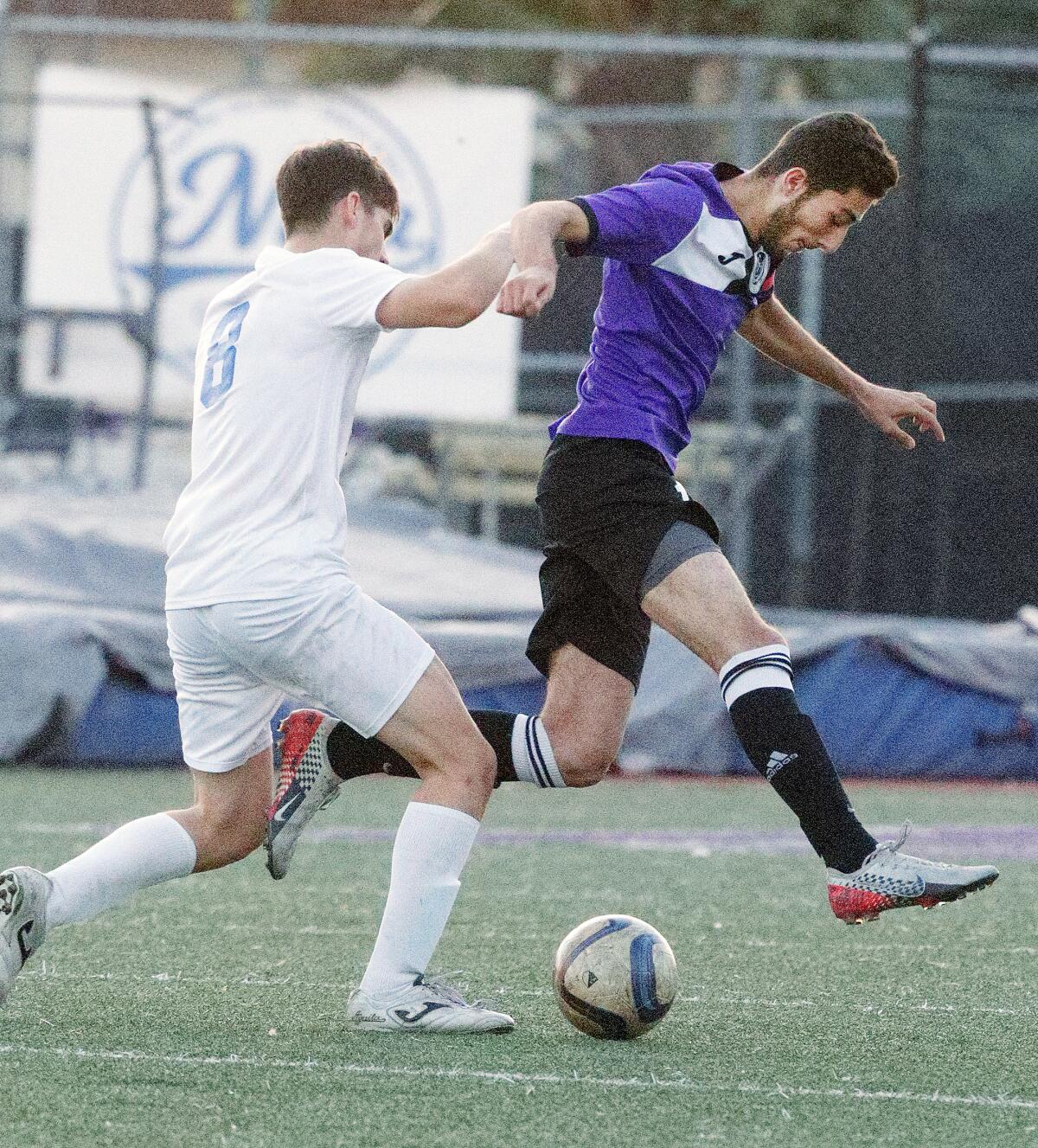 Hoover’s Kevin Mirzakhanian, right, beats Burbank defender Garik Kirahosyan to score his third goal of the game in a Pacific League boys' soccer game at Hoover High School on Friday, January 3, 2020.