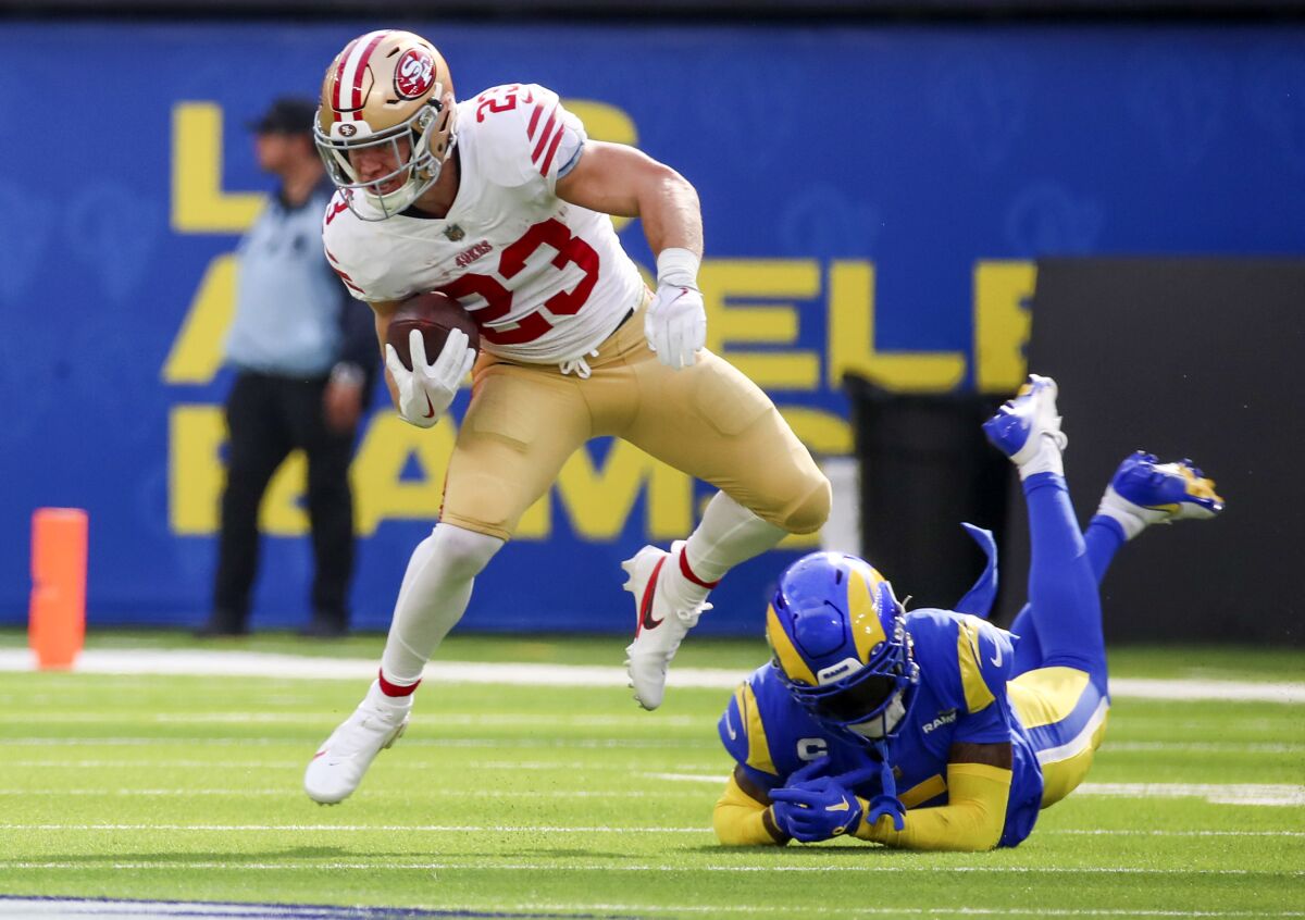 San Francisco's Christian McCaffrey evades a tackle attempt by Rams cornerback Jalen Ramsey in the third quarter.