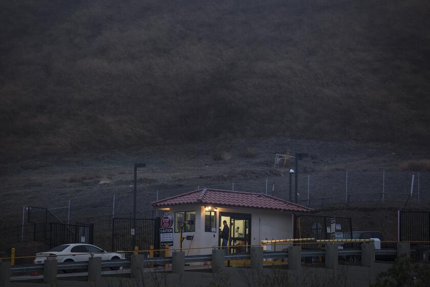 A security guard stands at the entry point to Southern California Gas Co.'s Aliso Canyon storage facility near Porter Ranch.