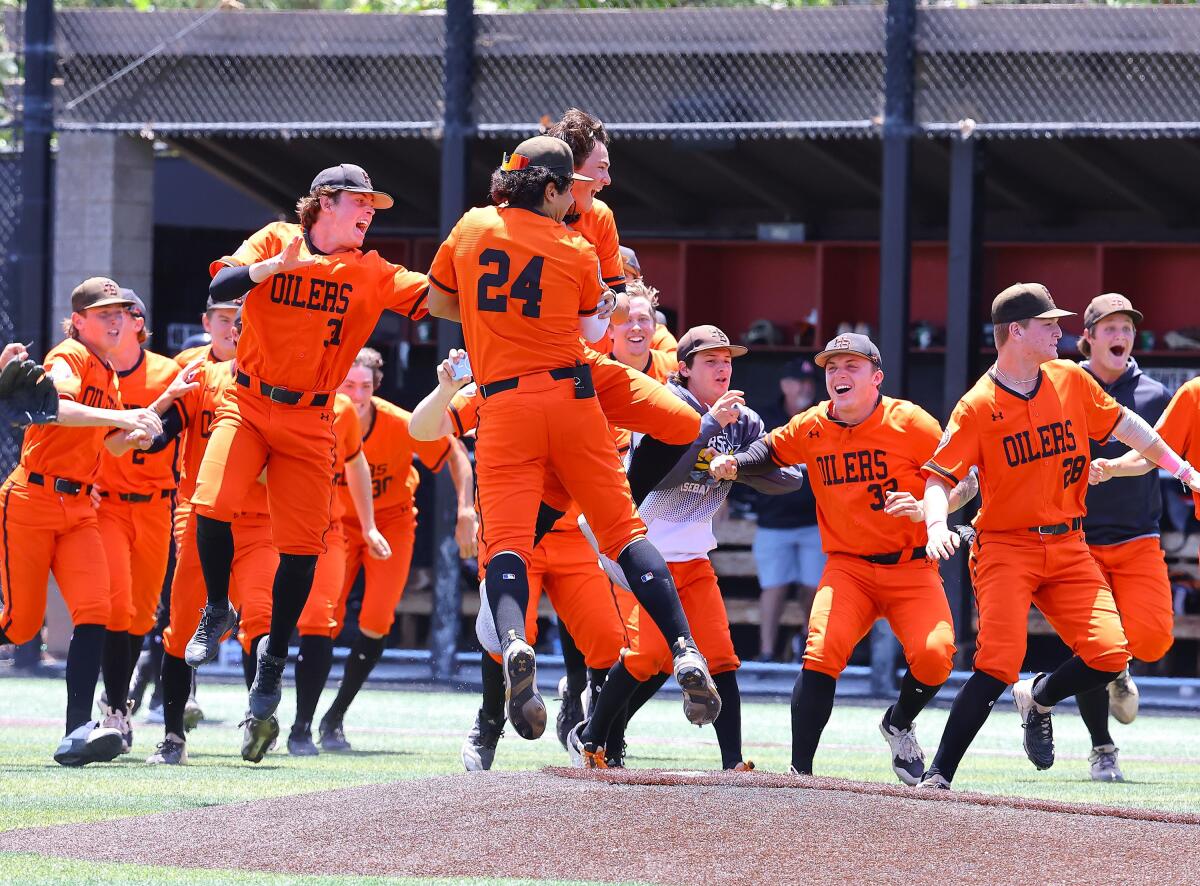 Huntington Beach players celebrate after defeating JSerra for the Division 1 regional baseball title on June 4, 2022.