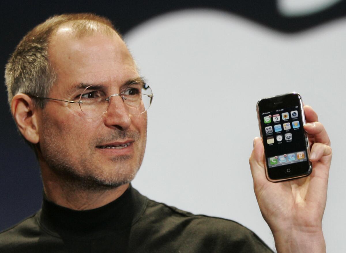 Steve Jobs with the new iPhone in 2007. Apple executives have gotten behind a new biography of Jobs.