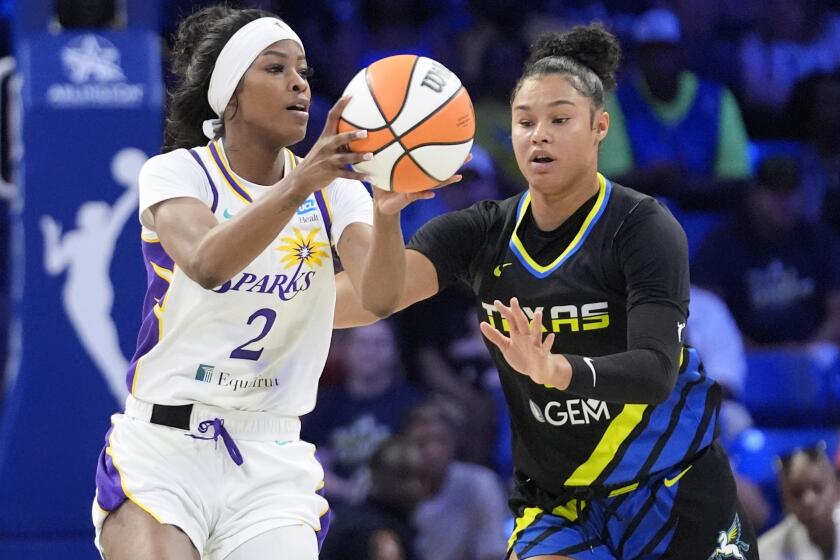 Los Angeles Sparks forward Rickea Jackson (2) takes a pass in front of Dallas Wings forward Satou Sabally, right, during the first half of a WNBA basketball game in Arlington, Texas, Sunday, Aug. 25, 2024, (AP Photo/LM Otero)