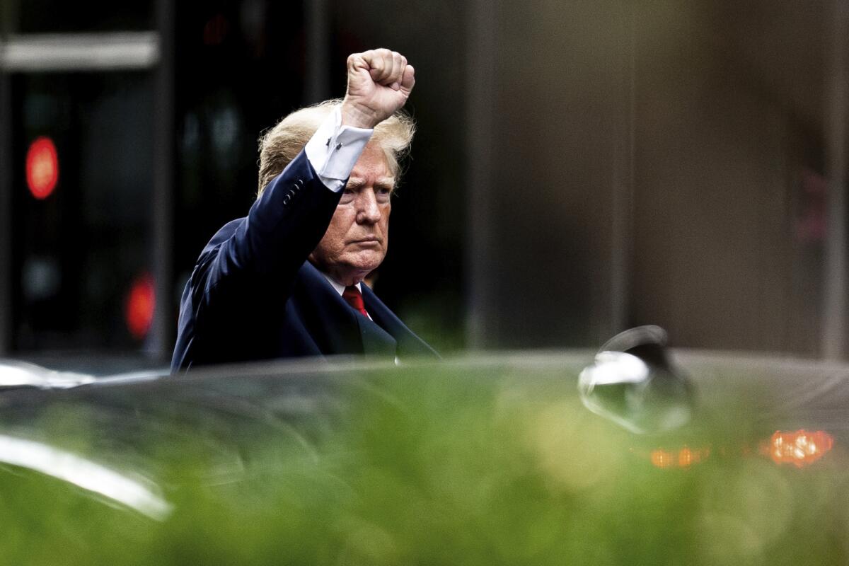 Former President Donald Trump gestures as he departs Trump Tower, Wednesday