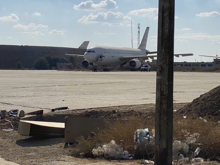 Un avión dañado se encuentra en la pista del aeropuerto de Bagdad que sufrió un ataque de seis cohetes el viernes 28 de enero de 2022. El ataque causó daños pero no víctimas. (AP Foto/Ali Abdul Hassan)