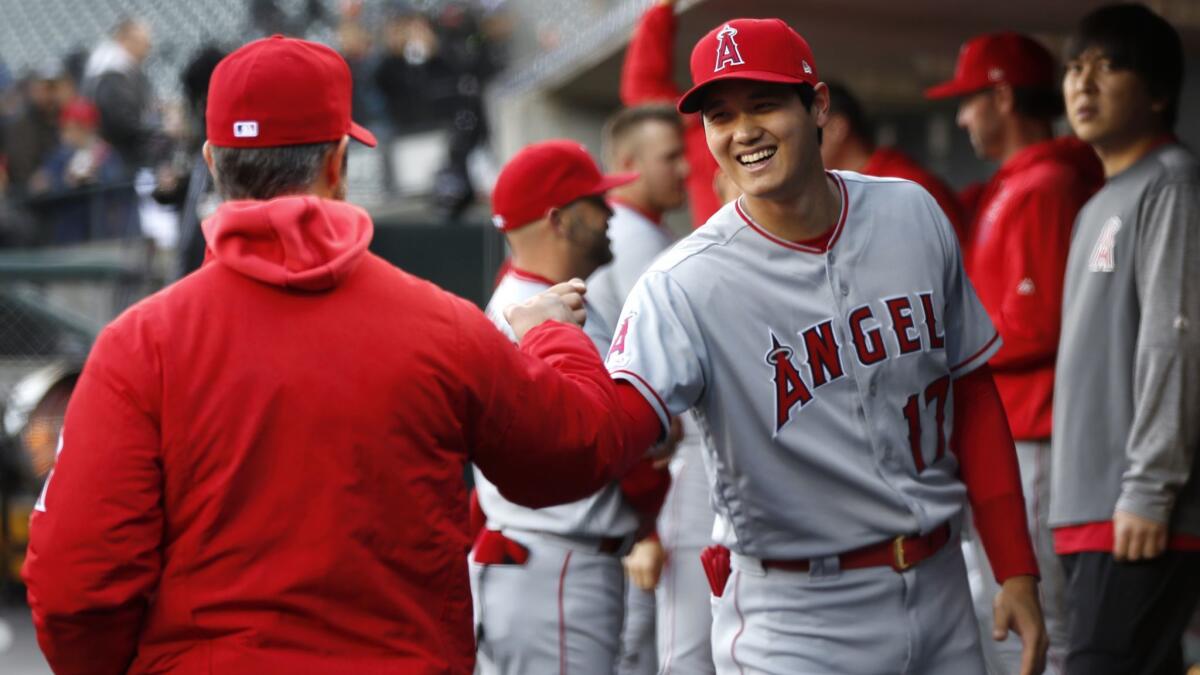 Angels designated hitter Shohei Ohtani fist bumps manager Brad Ausmus before making his season debut against the Detroit Tigers on May 7.