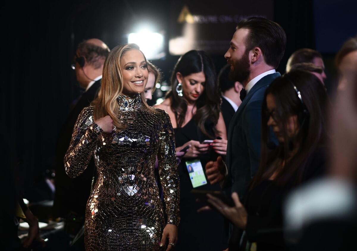 Jennifer Lopez, left, chats with Chris Evans backstage during the 91st Academy Awards.
