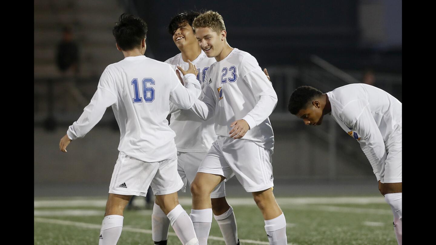 Fountain Valley High's Sebastian Rus (23) celebrates with teammates after giving the Barons a 1-0 lead against Newport Harbor during the first half in a Sunset Conference crossover match at Newport Harbor High on Wednesday, December 19, 2018.
