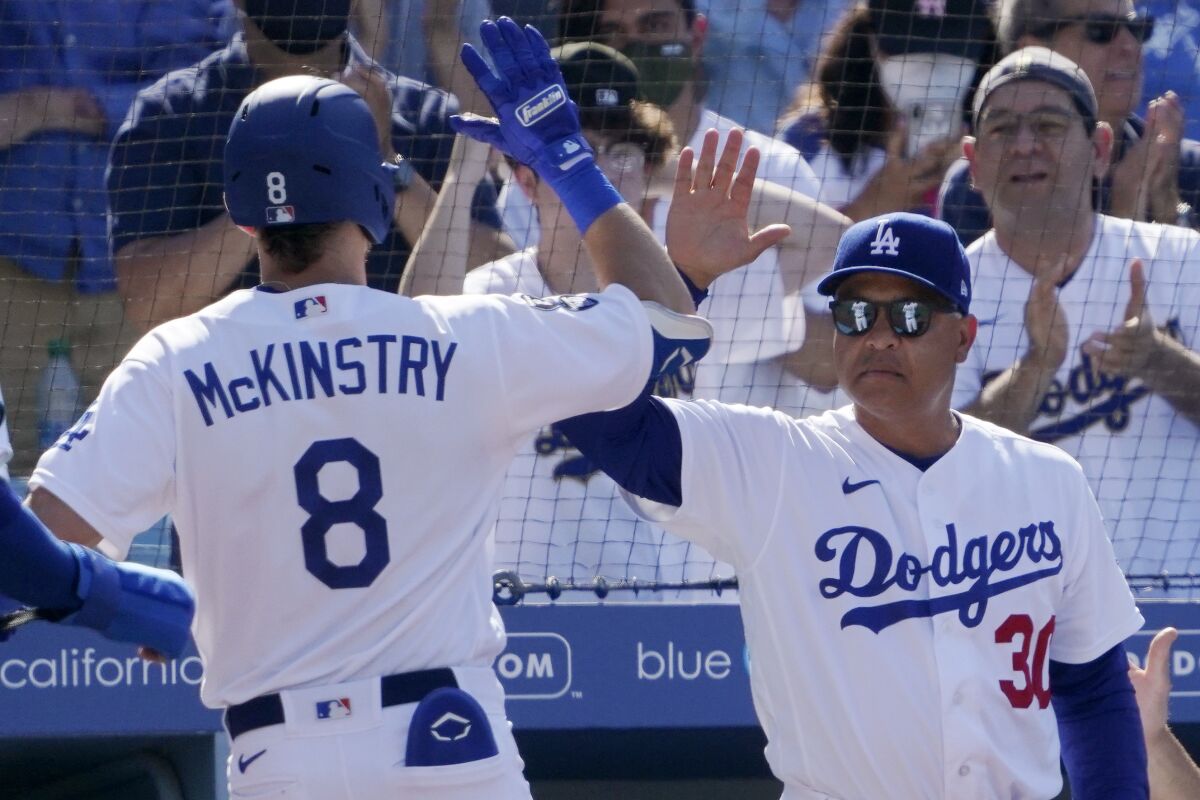 Los Angeles Dodgers' Zach McKinstry, left, is congratulated by manager Dave Roberts after hitting a grand slam.