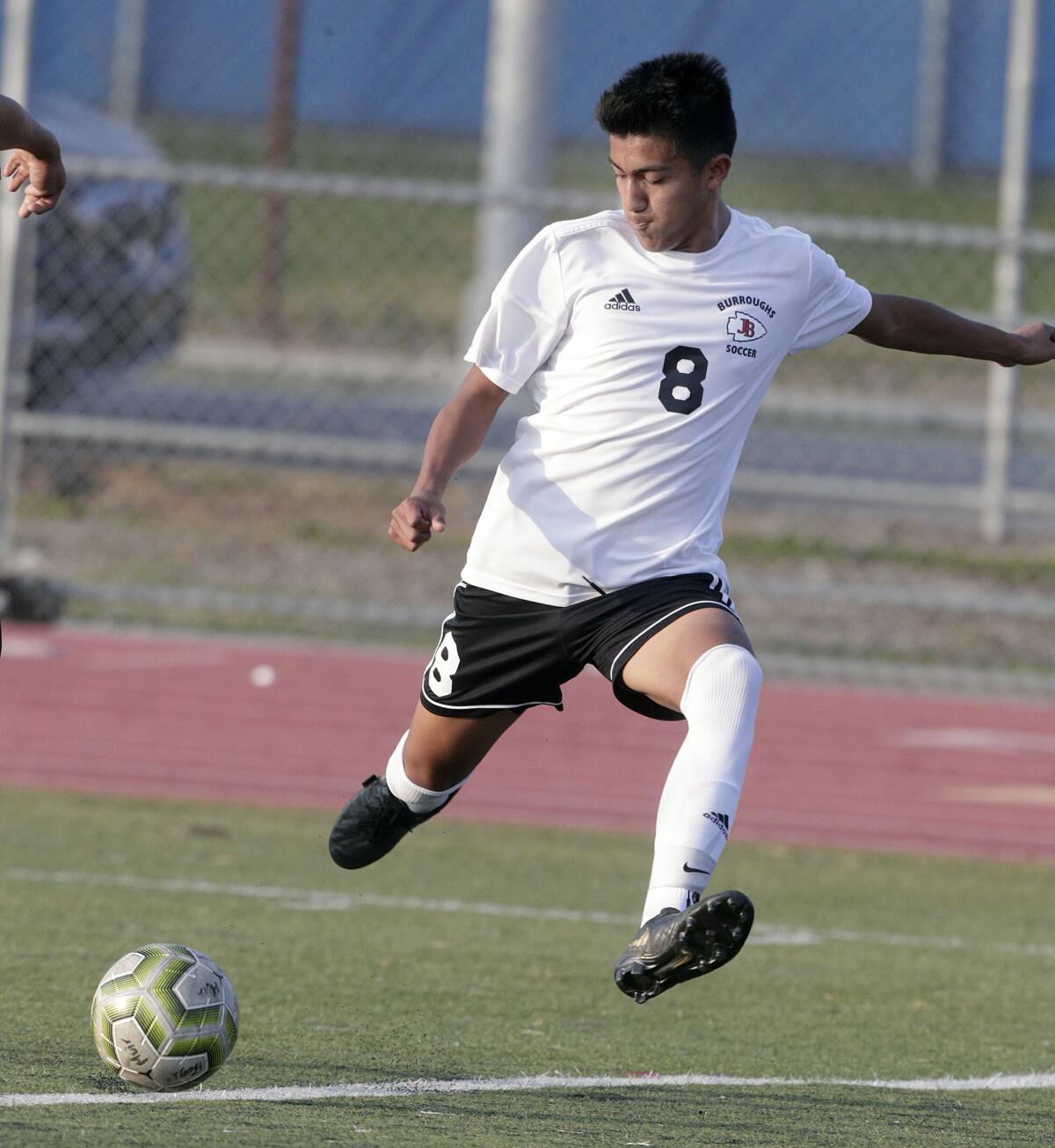 Burroughs' Elias Galaviz strides into a shot against Muir in a Pacific League boys' soccer game on Tuesday at Muir.