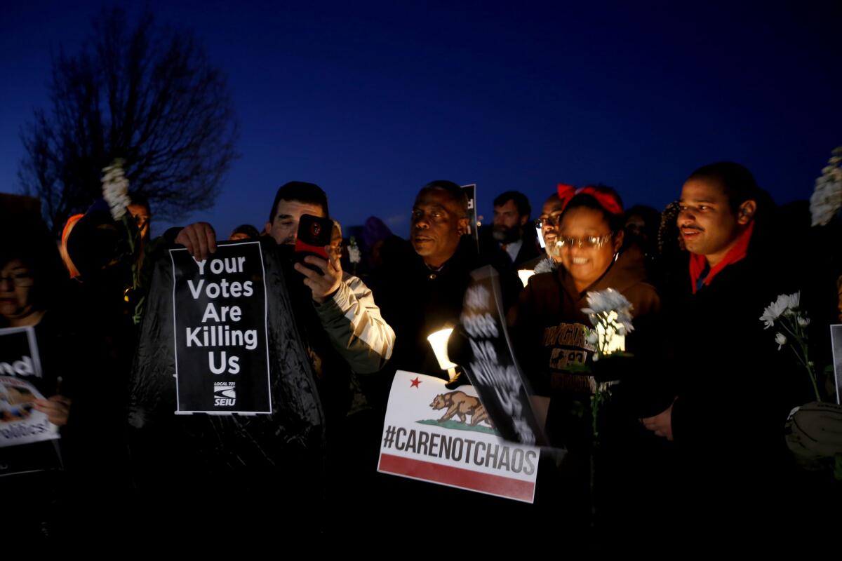 Demonstrators hold a candlelight vigil in Lancaster in 2017 to demand a town hall meeting with Rep. Steve Knight (R-Palmdale) to discuss the Trump administration's immigration and healthcare policies.