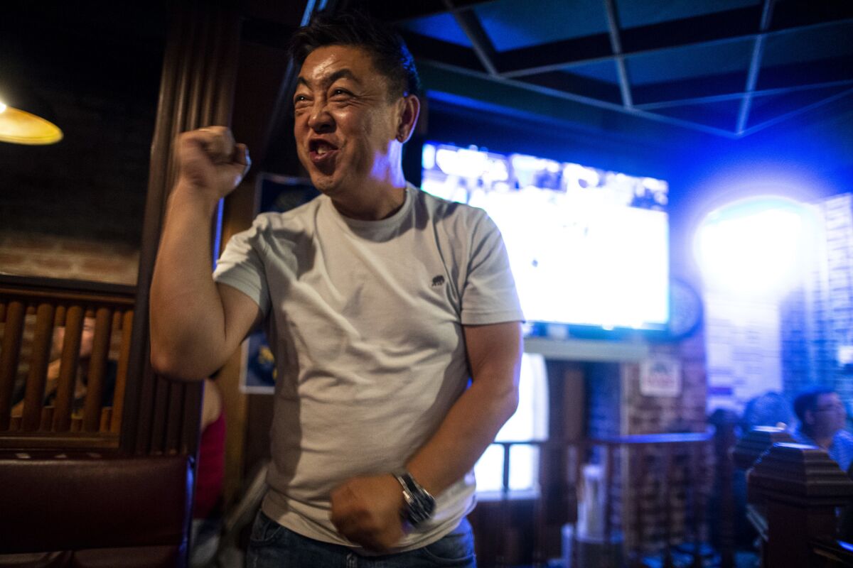 Kenny Gi cheers while watching Game 1 of the National League Division Series between the Dodgers and the Atlanta Braves at OB Bear in Koreatown. (Kent Nishimura / Los Angeles Times)