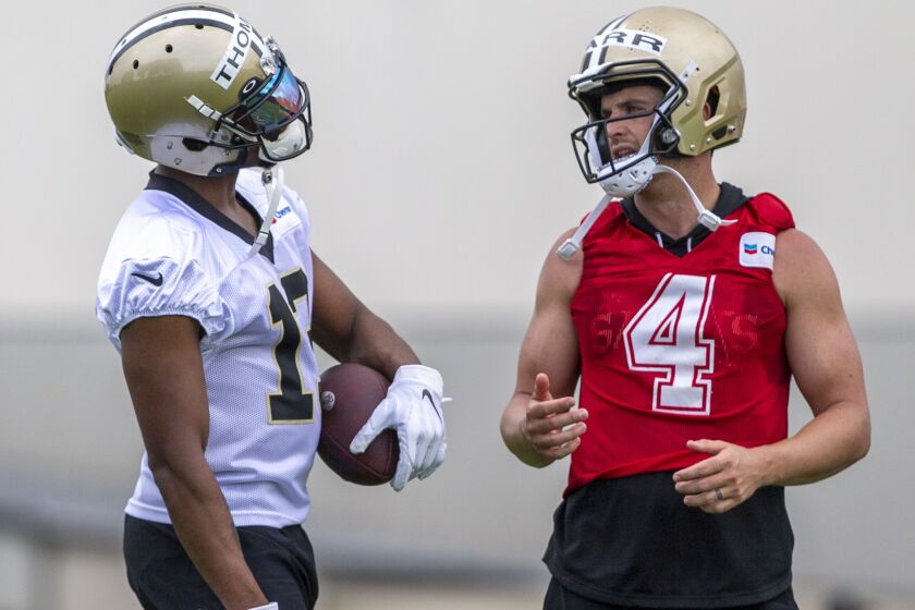 New Orleans Saints wide receiver Michael Thomas (13) talks with quarterback Derek Carr (4) during NFL football practice in Metairie, La., Tuesday, June 6, 2023. (Catie Shea/The Times-Picayune/The New Orleans Advocate via AP)