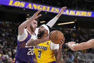 Los Angeles Lakers forward Anthony Davis, right, goes up for a shot as Phoenix Suns center Udoka Azubuike defends during the first half of an NBA preseason basketball game Thursday, Oct. 19, 2023, in Thousand Palms, Calif. (AP Photo/Mark J. Terrill)