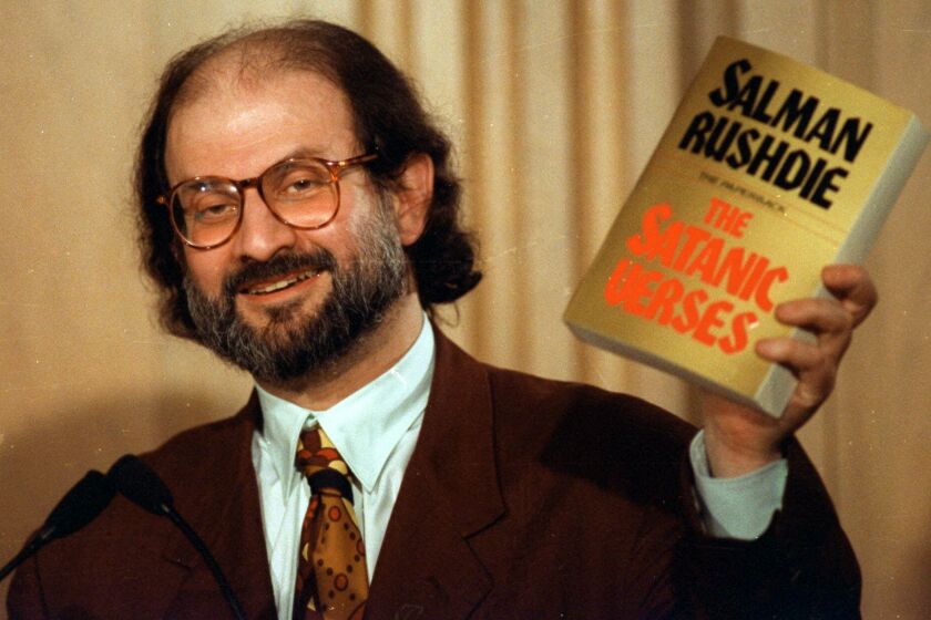 Author Salman Rushdie holds up a copy of his controversial book, "The Satanic Verses" during a 1992 news conference in Arlington, Va. Iran's foreign minister said Thursday SEPT. 24, 1998 that his government would distance itself from a $2.5 million reward for killing British novelist Salman Rushdie, and was ready to exchange ambassadors with Britain. (AP Photo/Ron Edmonds)