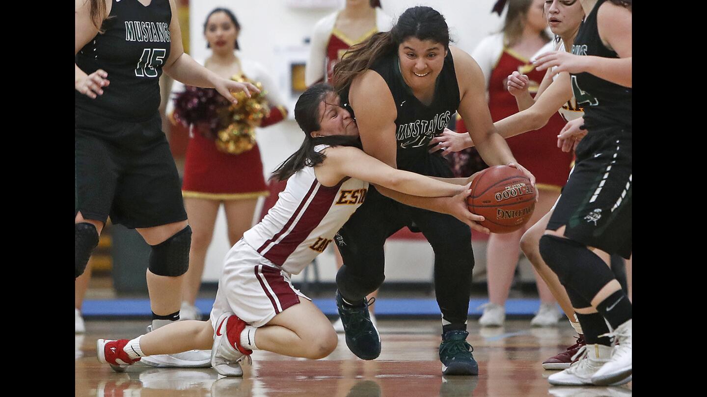 Costa Mesa High's Katie Belmontes, right, is fouled by Estancia's Cielo Cruz as the Eagles turn the ball over during the first half in a Battle for the Bell girls' basketball game on Wednesday.
