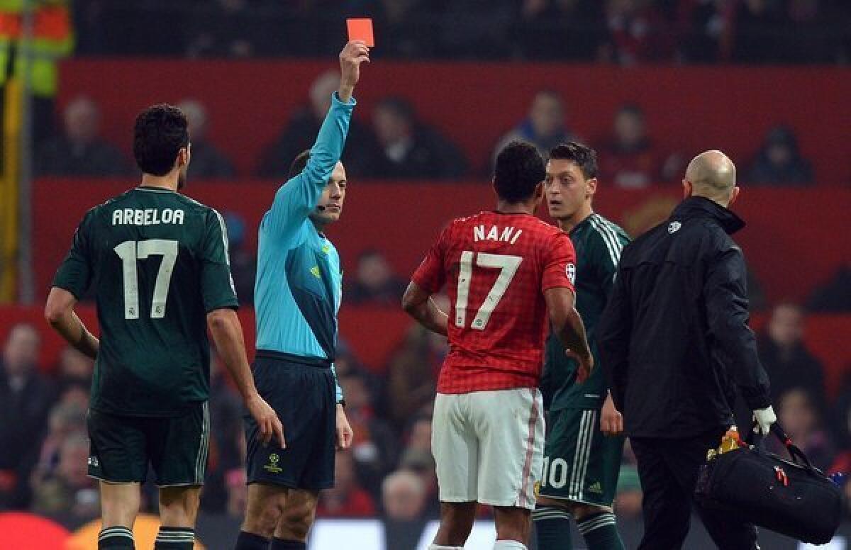 Turkish referee Cuneyt Cakir shows Manchester United midfielder Nani the red card to send him off during a Champions League match against Real Madrid.