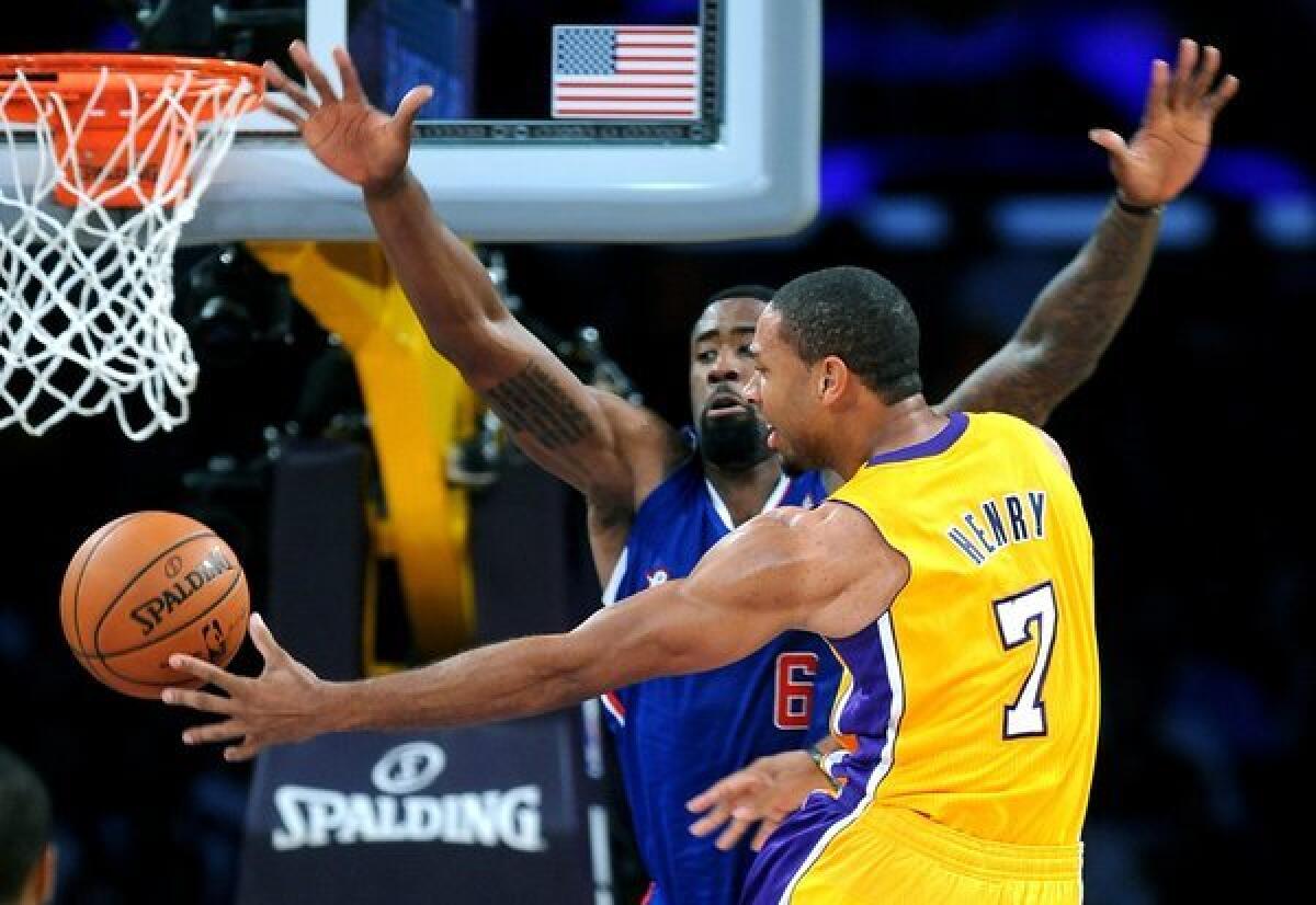 Xavier Henry slips a pass behind DeAndre Jordan during the Lakers' 116-103 home-opening win over the Clippers.