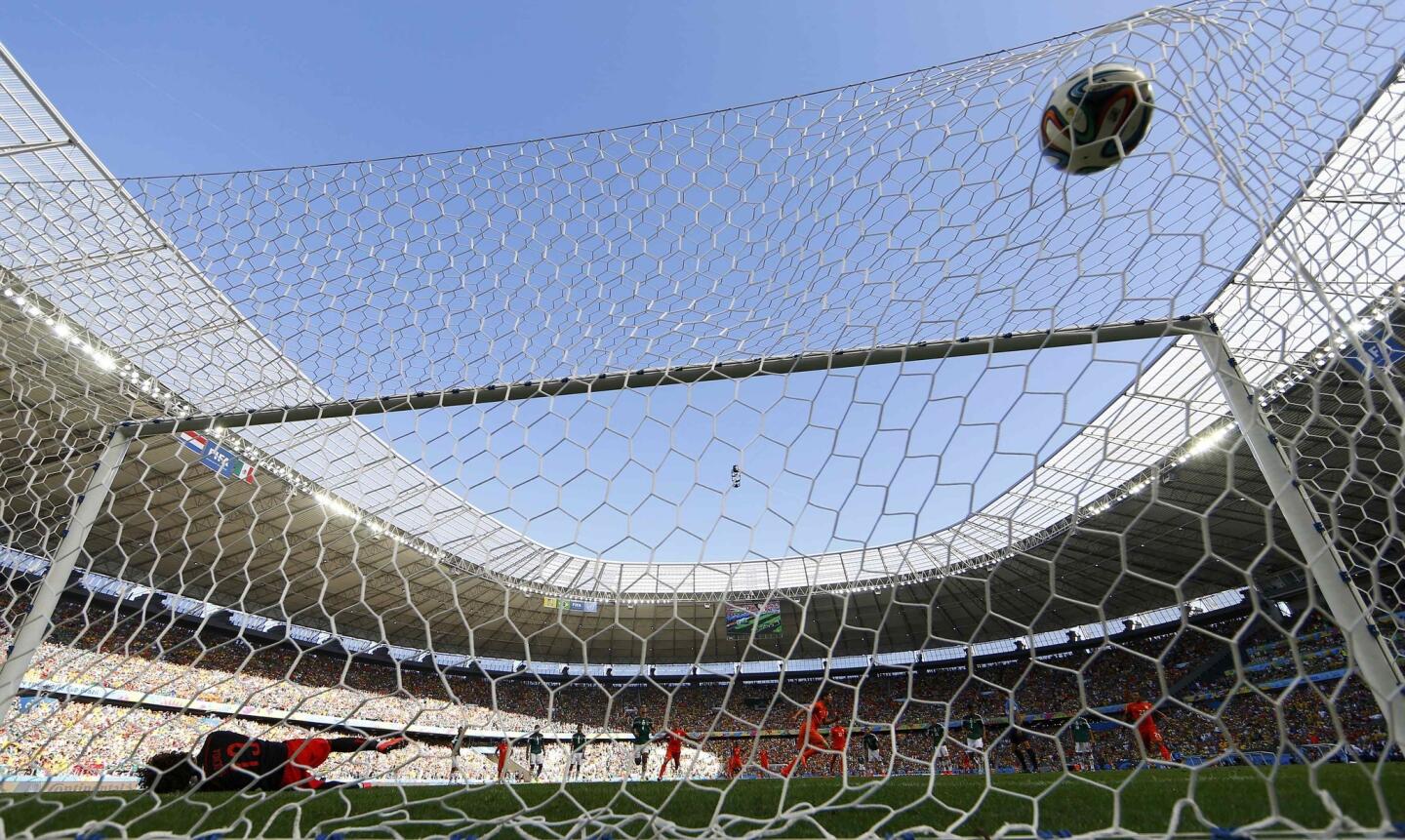 Mexico's goalkeeper Ochoa dives but fails to prevent a goal during a penalty kick by Klaas-Jan Huntelaar of the Netherlands in their 2014 World Cup round of 16 game at the Castelao arena in Fortaleza