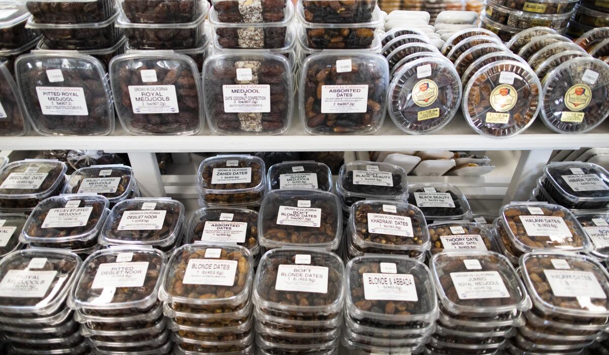 Clear containers filled with dates line two shelves.