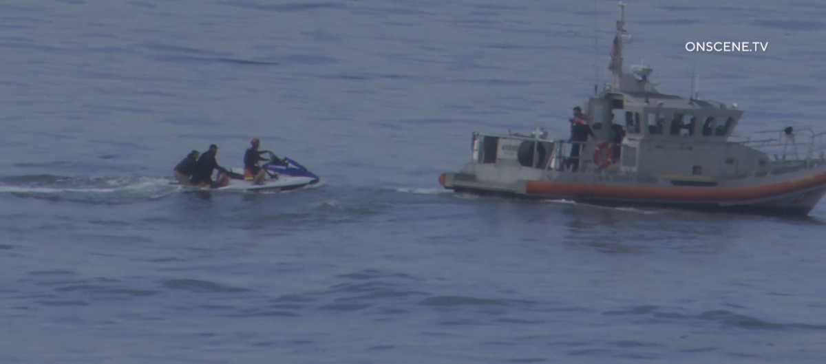 Lifeguards rescued 13 people from a beach in San Diego County after a suspected smuggling boat capsized early Monday.