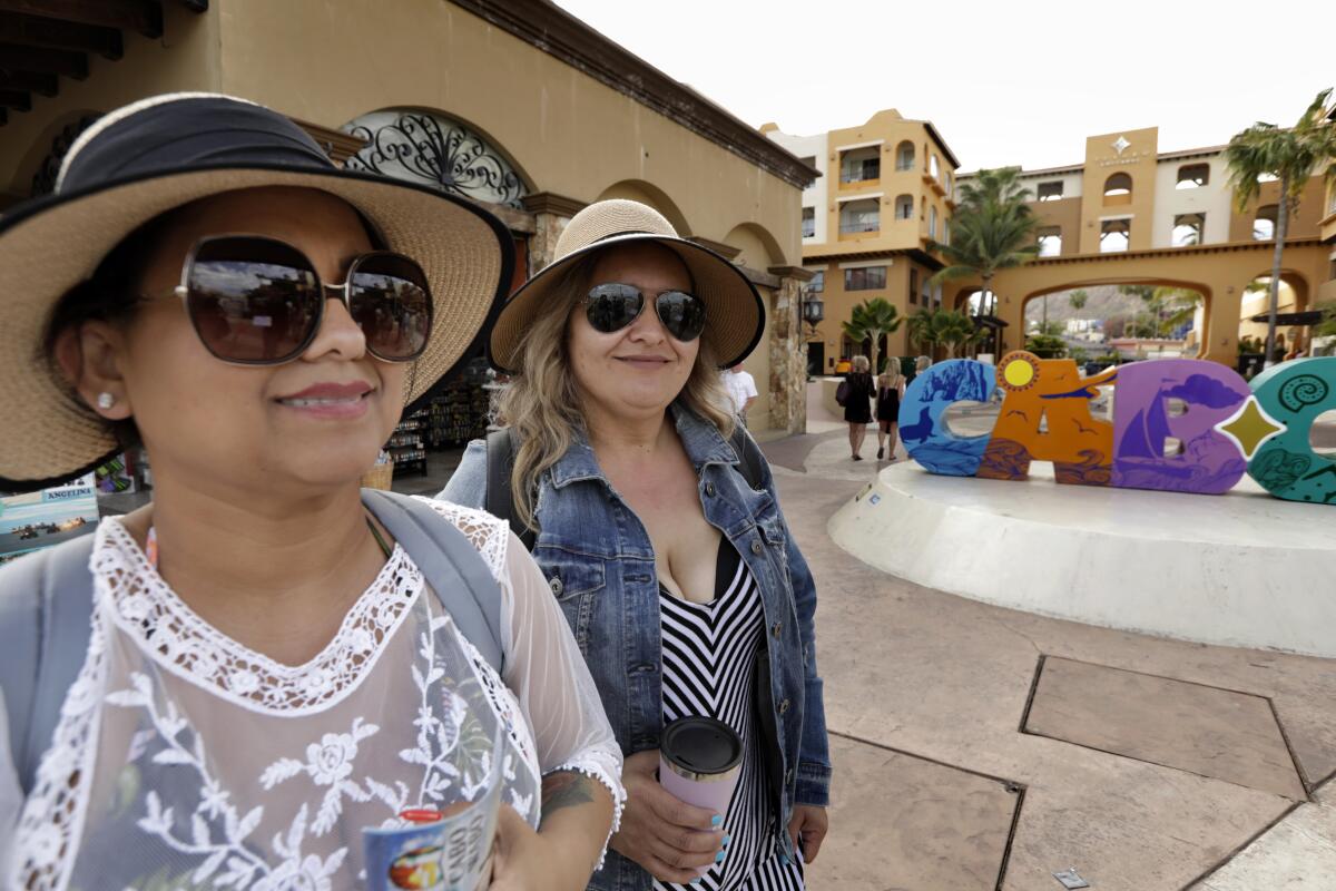 At the marina in Cabo San Lucas, Naomi Alcazar, 40, of Oxnard and Esperanza Barragan, 38, of Ventura are enjoying a vacation, but still worry about the coronavirus.