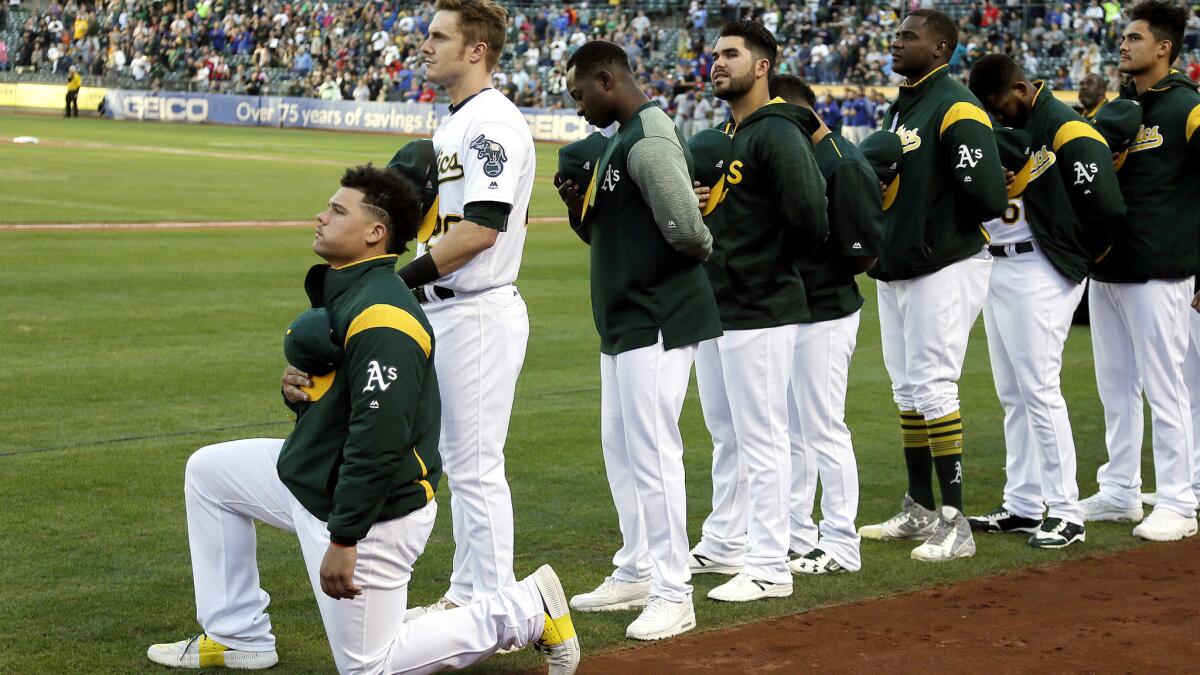 Bruce Maxwell kneels during the national anthem before the start of the A's game against the Rangers on Saturday night in Oakland.