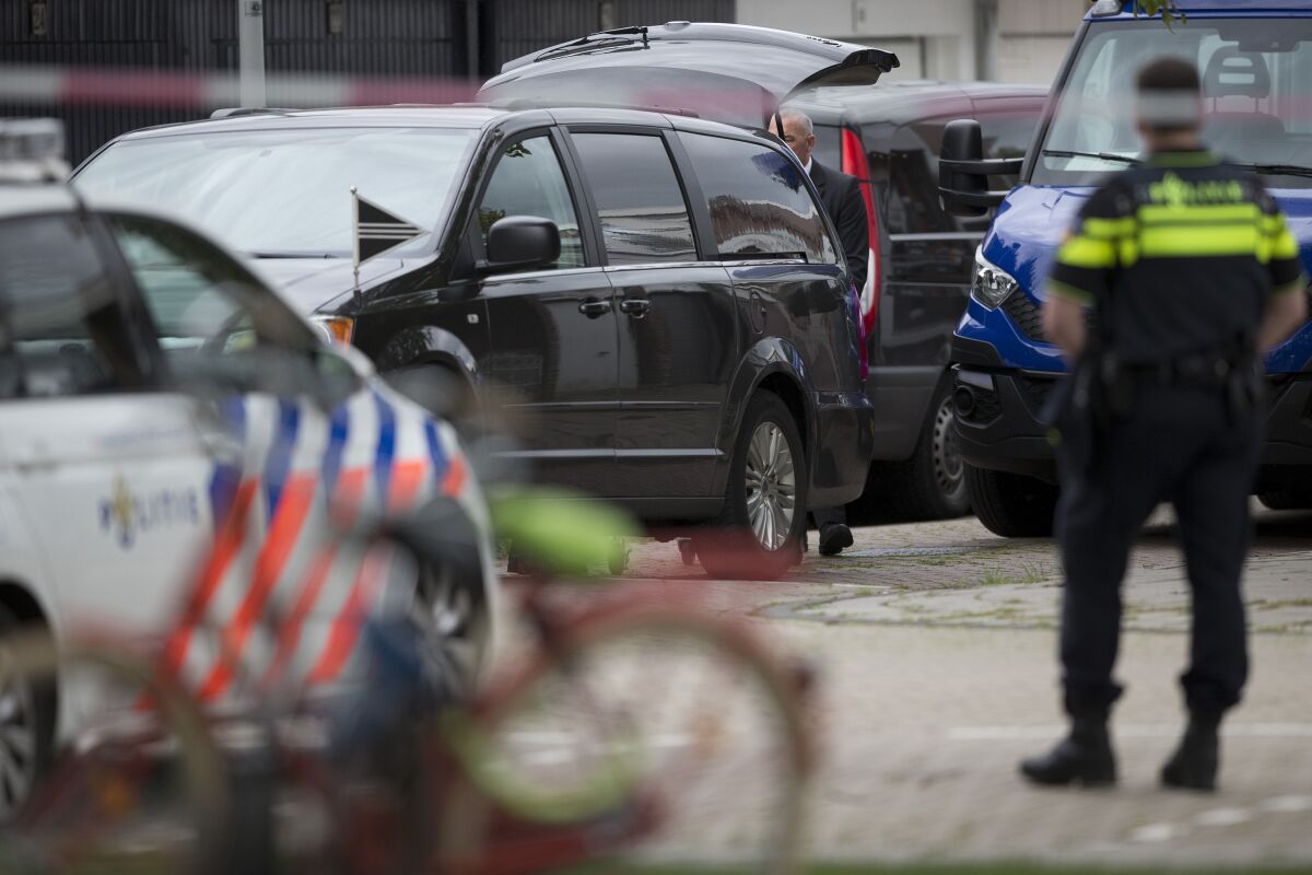 FILE - In this Wednesday, Sept. 18, 2019 file photo, the body of a lawyer who represented a key witness in a major Dutch organized crime trial is carried into a hearse after he was gunned down in Amsterdam, in Amsterdam, Netherlands. Two men were convicted Monday, Oct. 11, 2021, and sentenced to 30 years for the murder of a Dutch lawyer who represented a witness in a high-profile criminal case against suspected gangland bosses, a slaying that shocked the nation and sparked calls for a tougher crackdown on organized crime. (AP Photo/Peter Dejong, file)