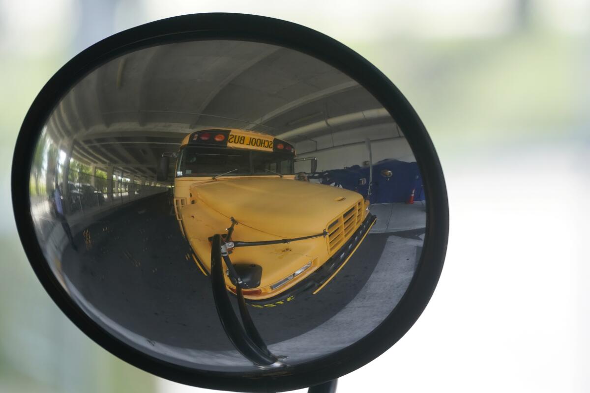 A diesel-powered school bus is reflected in a mirror 