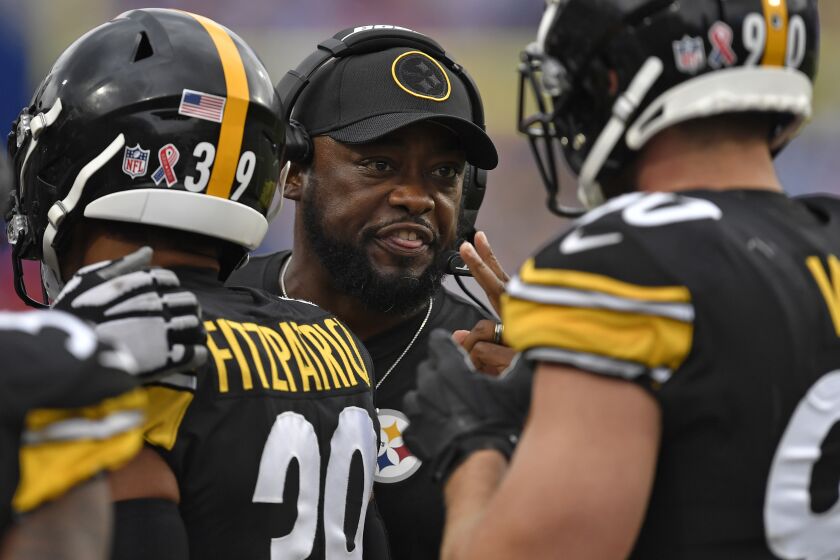 Pittsburgh Steelers' Mike Tomlin, center, talks with T.J. Watt (90) during the second half of an NFL football game against the Buffalo Bills in Orchard Park, N.Y., Sunday, Sept. 12, 2021. (AP Photo/Joshua Bessex)