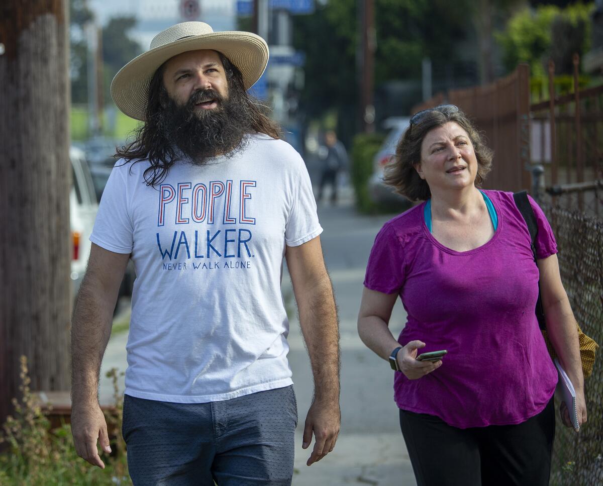 Nita Lelyeld walks alongside people Walker Chuck McCarthy in Los Angeles.