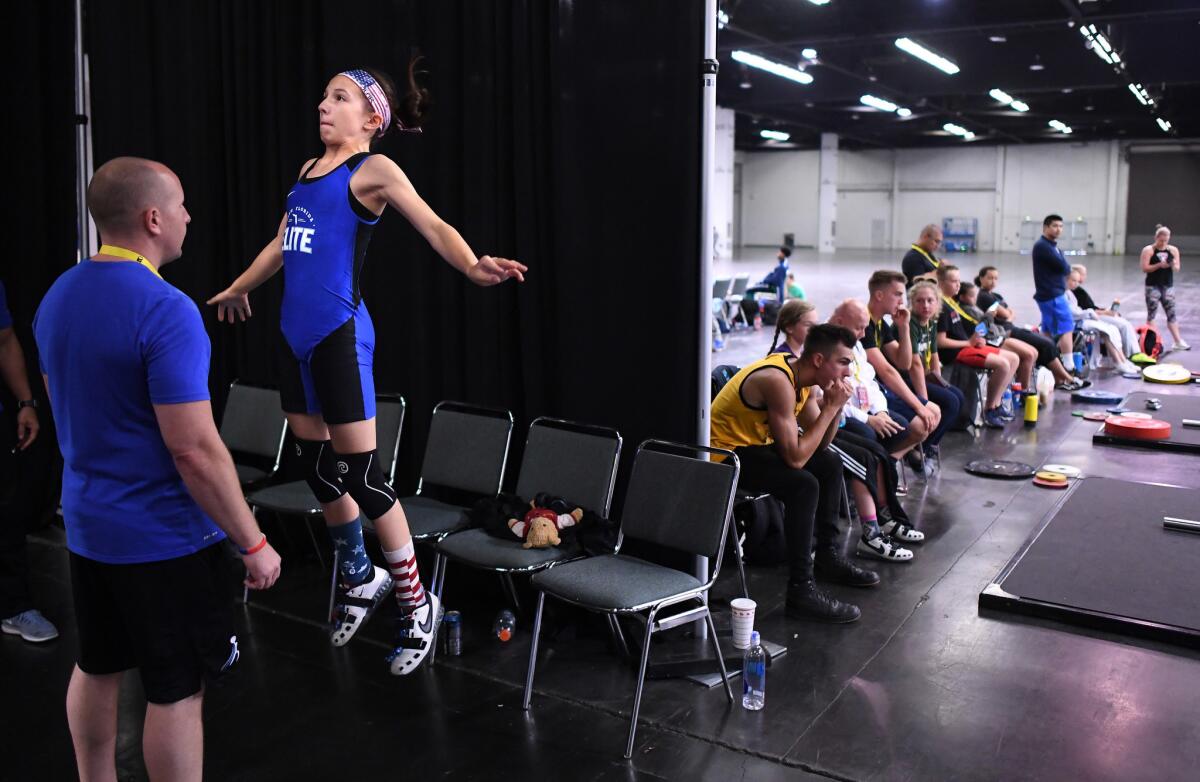 Addison Griffith warms-up before a lift in the under 13 category. (Wally Skalij / Los Angeles Times)