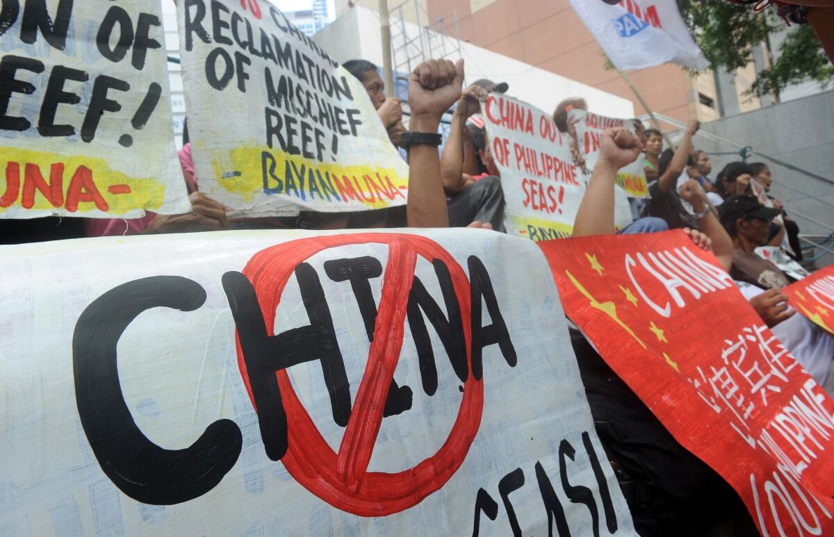 Filipino protesters display placards during a rally outside China's consular office in Manila on April 17 against the country's claim to islands and reefs in the South China Sea.