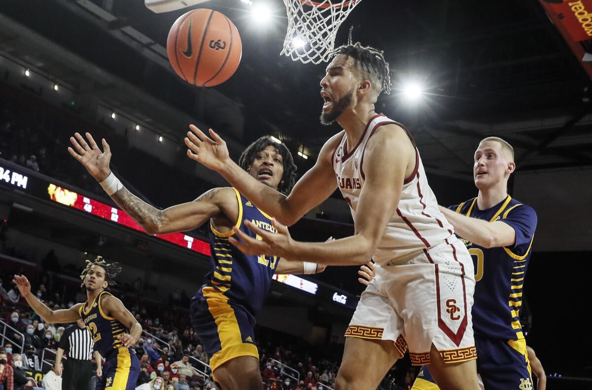 USC forward Isaiah Mobley, center, tries to control the ball against UC Irvine forwards Austin Johnson and Collin Welp.
