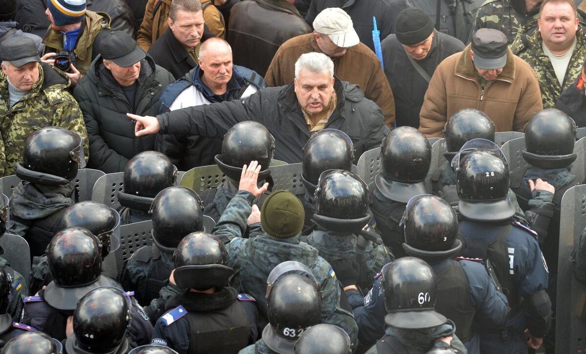 A protester argues with police in front of the Ukrainian parliament in Kiev on Tuesday. Lawmakers overwhelmingly adopted a bill dropping Ukraine's nonaligned status.